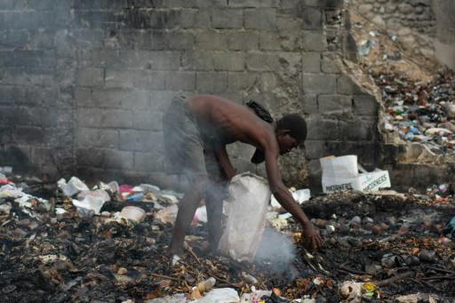 Un hombre busca entre los restos de basura en Puerto Príncipe el 13 de abril de 2024