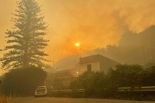 El humo de un incendio forestal envuelve unas casas cerca de Messina, en la isla italiana de Sicilia, el 26 de julio de 2023