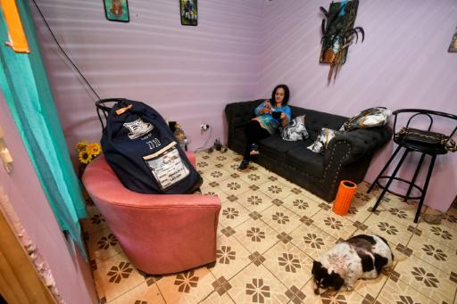 Priscilla Herrera toma café y revisa el celular en su casa, junto a la maleta que contiene las boletas de la elección presidencial, en San José, el 28 de enero de 2026