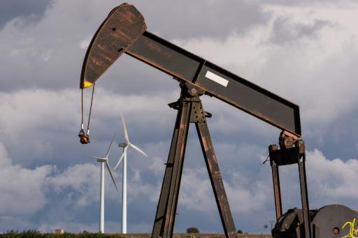 An oil pump is pictured at an obsolete oilfield, with wind turbines in the background, in Sargentes de la Lora on March 13, 2026, near Burgos in northern Spain, where oil first flowed in Spain in 1964. Spain's leftist government yesterday said it would soon present a plan to contain the Middle East war's impact on electricity and fuel prices in one of the most dynamic developed economies. The closure of the Strait of Hormuz, a vital waterway for oil and gas exports from the energy-rich Gulf, following the US-Israeli strikes on Iran from February 28 has roiled world energy markets.