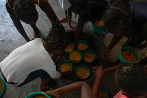 Unos niños reciben comida en una escuela de Puerto Príncipe reconvertida en refugio para los desplazados por la violencia ligada a las pandillas, el 22 de abril de 2024