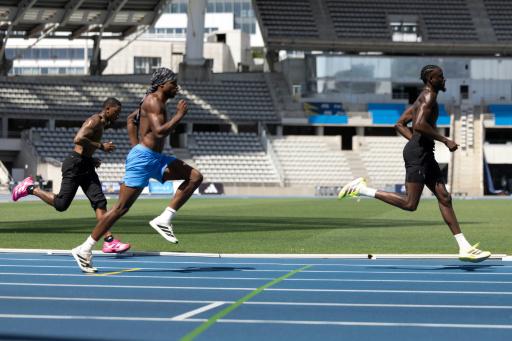 El atleta estadounidense Noah Lyles (centro) entrena junto a Jordan Anthony (izquierda) y Jereem Richards (derecha) el 25 de junio de 2026 en el estadio Charlety en París