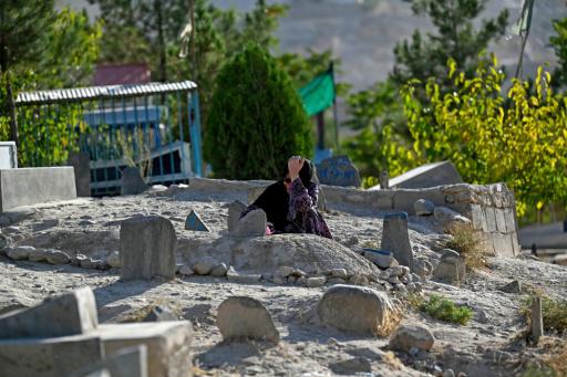 Una mujer afgana reza ante las tumbas de sus familiares el 25 de agosto de 2026 en la llamada 'colina de los mártires' de Kabul
