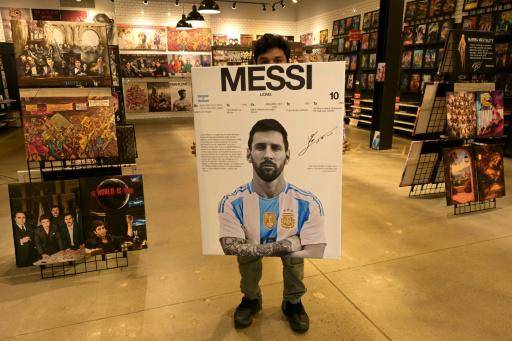 Un vendedor posa con una pancarta del astro argentino Lionel Messi en una tienda cercana a la concentración de la selección argentina en Kansas City, Misuri, el 7 de junio de 2026