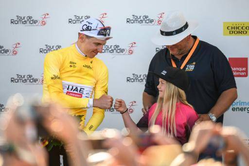 El ciclista esloveno Tadej Pogacar choca el puño con una niña tras recibir el maillot amarillo de líder del Tour de Romandía el 1 de mayo de 2026 en Orbe, Suiza