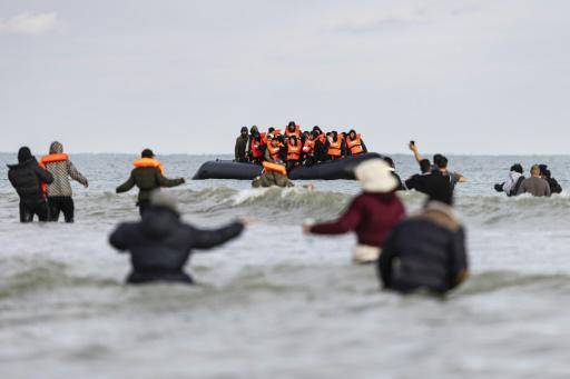 Un grupo de migrantes en torno a un bote de traficantes que intenta cruzar el canal de la Mancha desde la costa de Gravelines, en Francia, hacia el Reino Unido, el 26 de abril de 2024
