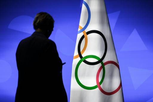 Un miembro del Comité Olímpico Internacional es fotografiado junto a la bandera olímpica durante la sesión de la organización en Lausana (Suiza), el 24 de junio de 2026