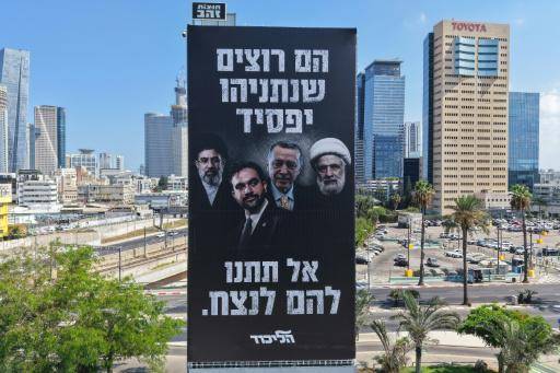 Cartel electoral del Likud en Tel Aviv, con el líder supremo iraní, el alcalde de Nueva York, el presidente turco y el jefe de Hezbolá y la leyenda en hebreo: Ellos quieren que Netanyahu pierda. No permitas que ellos ganen.
