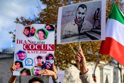 Unas manifestantes muestran un retrato del rapero Toomaj Salehi (drcha.) y de unos niños muertos en las protestas en Irán, el 26 de noviembre de 2022 en Estambul