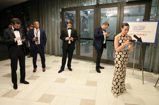 Unos reporteros miran sus teléfonos móviles tras el intento de asesinato del presidente de EEUU, Donald Trump durante la cena de gala de la Asociación de Corresponsales de la Casa Blanca (WHCA), en Washington, el 25 de abril de 2026
