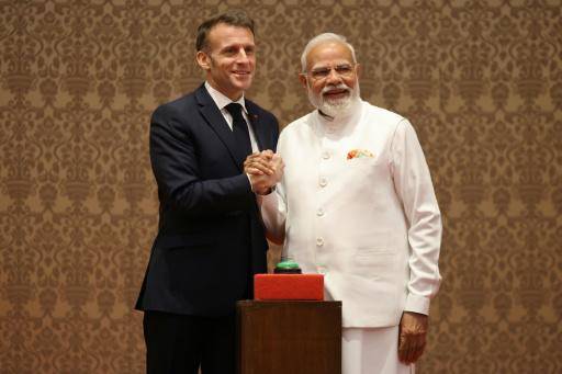 El presidente de Francia, Emmanuel Macron (izq.), y el primer ministro de India, Narendra Modi, posan delante de un botón para inaugurar virtualmente una línea de ensamblaje de helicópteros Airbus H-125, el 17 de febrero de 2026 en Bombay