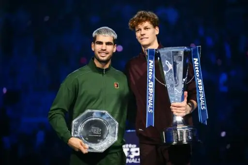 El italiano Jannik Sinner (izquierda) y el español Carlos Alcaraz posan con sus trofeos respectivos al término de la final del Masters de fin de temporada ganado por el italiano en Turín, el 16 de noviembre de 2025
