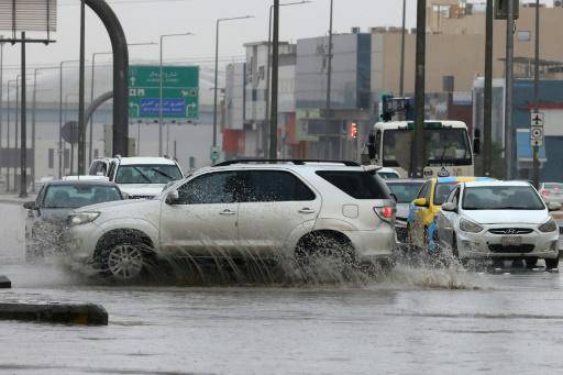 Unos vehículos circulan el 1 de mayo de 2024 en una calle de Riad inundada por las fuertes lluvias