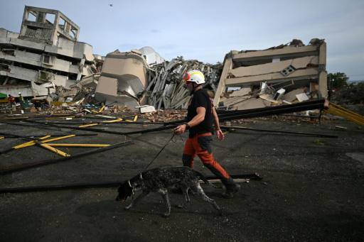 Un rescatista español camina junto a un perro rastreador en los escombros de edificios que colapsaron en Caraballeda, La Guaira, Venezuela, el 3 de julio de 2026