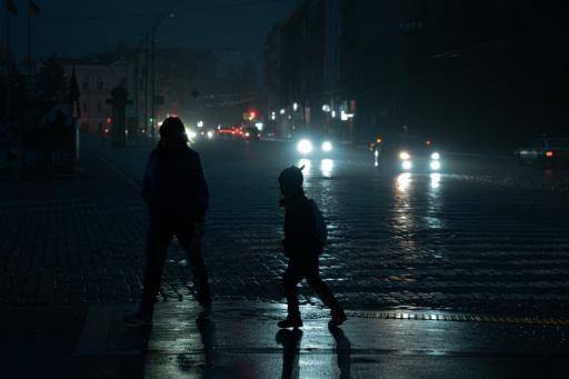 Unos peatones cruzan una calle sin alumbrado público por recientes ataques rusos con misiles y drones, el 10 de noviembre de 2025 en Járkov, al este de Ucrania