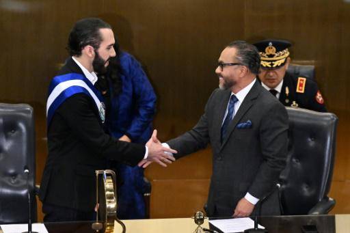 El presidente de El Salvador, Nayib Bukele (izq.), estrecha la mano del presidente de la Asamblea Legislativa, Ernesto Castro, en San Salvador antes de pronunciar su discurso a la nación el 1 de junio de 2023