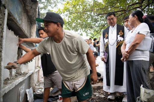 El sacerdote católico Flavie Villanueva (D), habla con Mary Ann Pajo mientras trasladan los restos de su hijo, víctima de la guerra contra las drogas del expresidente filipino Rodrigo Duterte, el 16 de febrero de 2026 en Manila
