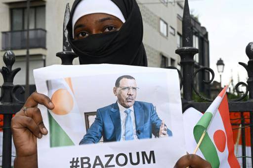 Una mujer sostiene una imagen del derrocado presidente de Níger, Mohamed Bazoum, durante una protesta frente a la embajada de ese país en París el 5 de agosto de 2023