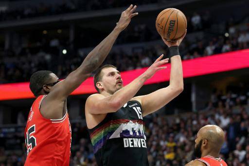 Nikola Jokic #15 of the Denver Nuggets goes to the basket against Jalen Smith #25 and Jevon Carter #5 in the first quarter at Ball Arena on November 17, 2025 in Denver, Colorado