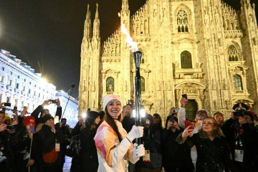 La bailarina Nicoletta Manni llega con la llama olímpica a la plaza de la Catedral (Duomo) de Milán el 5 de febrero de 2026, a un día de la ceremonia de apertura de los Juegos de Invierno de Milán-Cortina