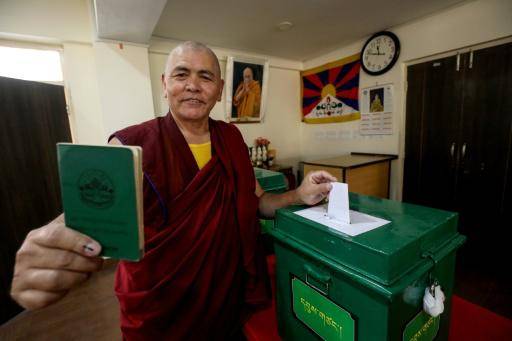 Un monje budista muestra su documento de identidad mientras vota en un colegio electoral de Dharamsala en los comicios parlamentarios del exilio tibetano, el 26 de abril de 2026 al norte de la India