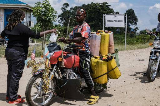 Un motorista se desinfecta las manos al cruzar a Uganda desde República Democrática del Congo desde el paso fronterizo de Busunga, en Bundibugyo, el 18 de mayo de 2026