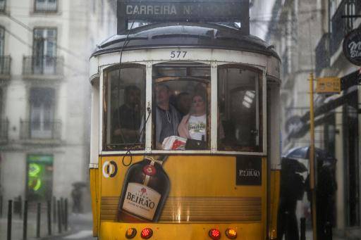 Unos turistas viajan en un tranvía de Lisboa bajo la lluvia provocada por la tormenta Aline el 19 de octubre de 2023