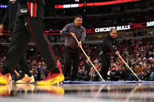 Miembros del equipo de mantenimiento de los Chicago Bulls tratan de dejar la pista en condiciones para el partido ante los Miami Heat el 8 de enero de 2026