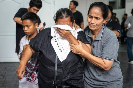 Familiares de victimas fallecidas en el incendio de un bar en Bangkok, el 14 de julio de 2026 en la capital tailandesa