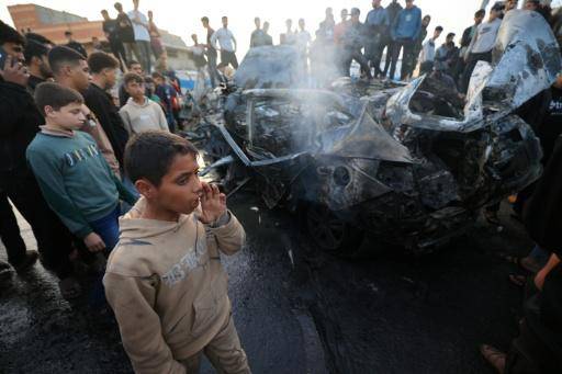 Unos palestinos rodean un vehículo alcanzado por un bombardeo israelí el 4 de abril de 2026 en el campamento de refugiados de Maghazi, en el centro de la Franja de Gaza