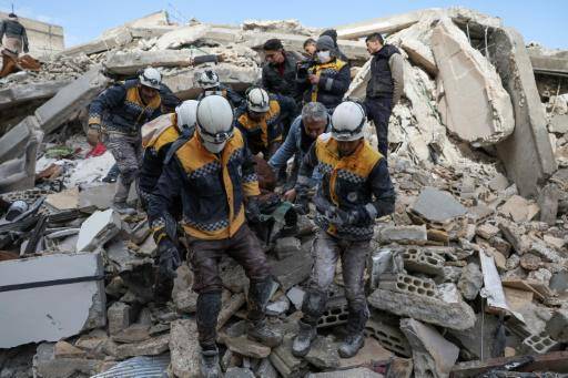 Miembros de los 'cascos blancos' se llevan a una víctima hallada entre los escombros de un edificio derribado por el terremoto, el 7 de febrero de 2023 en el pueblo de Azmarin, en la provincia de Idlib, al norte de Siria