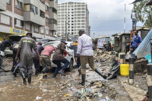 Varias personas empujan un vehículo atrapado en el centro de Nairobi por las inundaciones el 7 de marzo de 2026