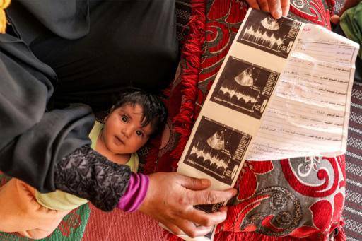 Um Khaled, una mujer siria de 27 años, observa las ecografías de su hija, nacida con un defecto cardíaco, en su pueblo de Halzun, Siria, el 10 de mayo de 2023