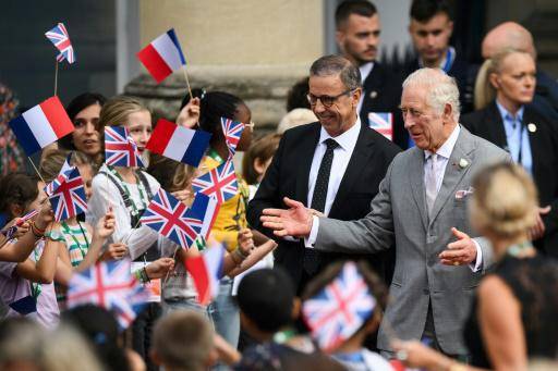El rey Carlos III saluda a varios niños junto al alcalde de Burdeos, Pierre Hurmic (centro), a su llegada al ayuntamiento el 22 de septiembre de 2023