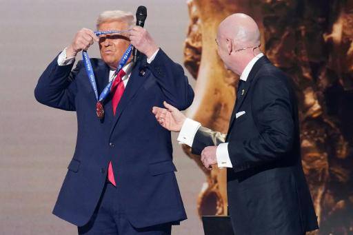 El presidente de los Estados Unidos, Donald Trump, se coloca el Premio de la Paz de la FIFA tras recibirlo de manos del patrón de la FIFA, Gianni Infantino (derecha), en el sorteo oficial del Mundial de 2026, celebrado en el Centro John F. Kennedy para las Artes Escénicas en Washington el 5 de diciembre de 2025