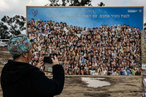Una mujer hace una foto de un cartel con retratos de las personas asesinadas o secuestradas el 7 de octubre de 2023 por islamistas de Hamás en el recinto del festival de música Tribe of Nova, en el sur de Israel, el 19 de febrero de 2024