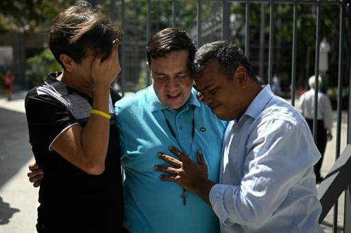 El activista Javier Tarazona (C) es recibido por su hermano José Rafael Tarazona (I) y el abogado Omar de Dios García tras su liberación de prisión en la iglesia La Candelaria, en Caracas, el 1 de febrero de 2026.
