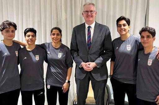 El ministro del Interior australiano Tony Burke junto a las cinco futbolistas iraníes qeu solicitaron asilo en Australia: Fatemeh Pasandideh, Mona Hamoudi y Atefeh Ramezanizadeh (a la izquierda del político) y Zahra Ghanbari y Zahra Sarbali (a su derecha), en una fotografía ofrecida por el ministerio del Interior sin precisar el lugar ni el día en el que se tomó