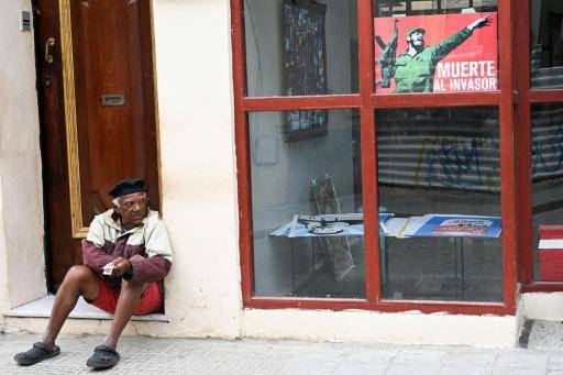 Un hombre está sentado cerca de un cartel del exlíder cubano Fidel Castro (1926-2016) en una calle de La Habana, el 16 de febvero de 2026