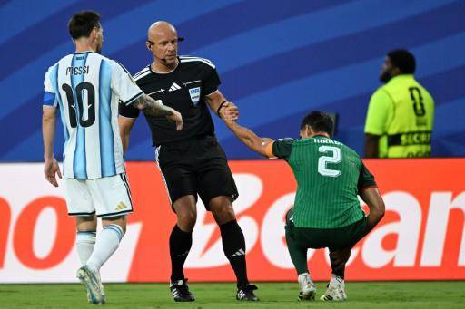 El árbitro polaco Szymon Marciniak ayuda a levantarse al defensor de Argelia Aissa Mandi tras una entrada del argentino Lionel Messi (izquierda), en partido del Grupo J del Mundial disputado en Kansas City el 16 de junio de 2026