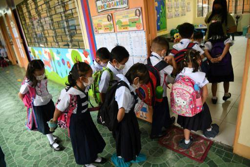 Un grupo de escolares con mascarillas entra en un aula el primer día del curso en Filipinas, el 22 de agosto de 2022 en Quezon City, un suburbio de Manila