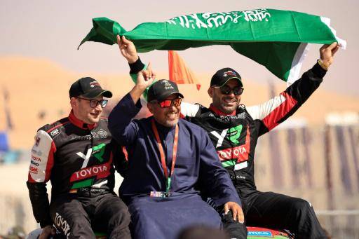 El piloto saudita Yazeed Al Rajhi (derecha) y su copiloto Edouard Boulanger (izquierda) celebran con el príncipe Khalid bin Sultan al Faisal el triunfo en el Rally Dakar, el 17 de enero de 2025 en Shubaytah (Arabia Saudita)