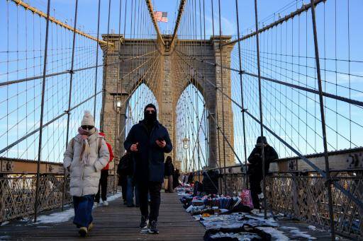 Pese a las bajas temperaturas, la gente camina por el puente de Brooklyn, en el distrito de Manhattan, en Nueva York, el 21 de enero de 2026