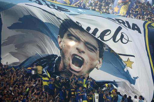 Hinchas de Boca Juniors exhiben una bandera con el rostro del fallecido astro argentino Diego Armando Maradona, durante el partido de octavos de final del torneo Clausura ante Talleres, que se disputó el 23 de noviembre de 2025 en el estadio La Bombonera, en Buenos Aires