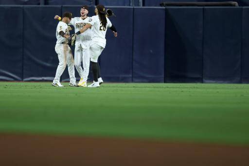 (De izq. a drcha.) Los jugadores de béisbol Ramón Laureano, Jackson Merrill y Fernando Tatis Jr., de los Padres, se abrazan tras derrotar a los Marineros de Seattle el 16 de abril de 2026 en San Diego (California, EEUU)