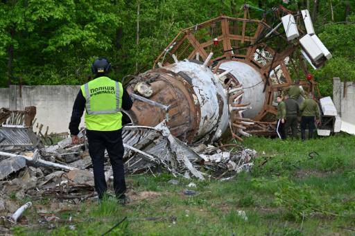 Un investigador de la policía ucraniana observa los restos de la torre de televisión de Járkov, semidestruida por un bombardeo ruso, el 22 de abril de 2024 en esa ciudad al este de Ucrania
