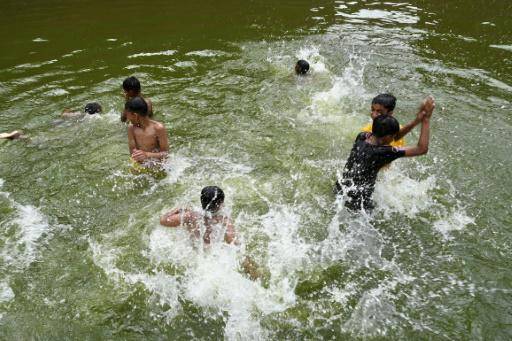 Unos niños se bañan en un estanque para refrescarse a causa de la ola de calor, el 17 de abril de 2024 en Daca, la capital de Bangladés
