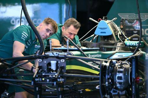 Mechanics work on the car of Aston Martin driver Fernando Alonso in Melbourne