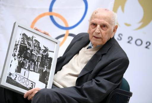 Charles Coste posa con una fotografía en la ceremonia de entrega de la Legión de Honor en las instalaciones del Comité de Organización de los Juegos Olímpicos y Paralímpicos de París 2024. En Saint-Denis (periferia norte de París), el 13 de abril de 2022