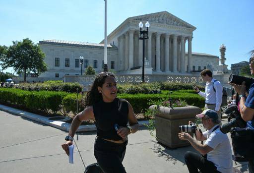 Una becaria de la Corte Suprema de EEUU corre para entregar a la prensa documentación el 30 de junio de 2026 en Washington